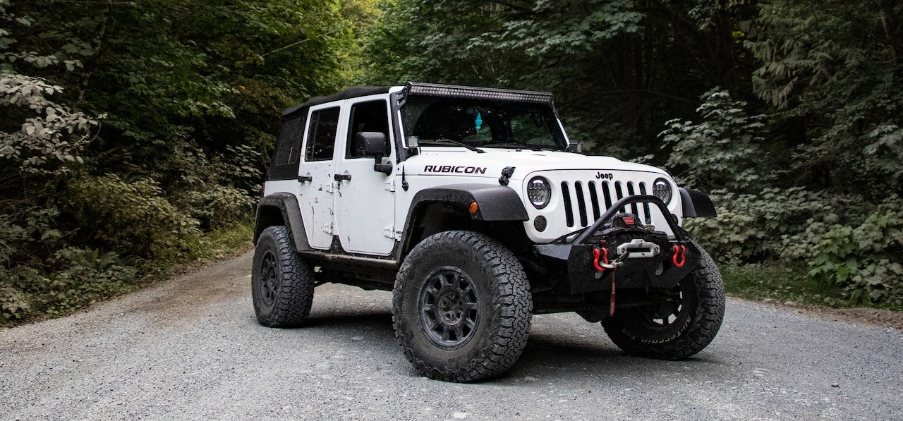 White Jeep Wrangler on Asphalt Road | Breast Cancer Car Donations