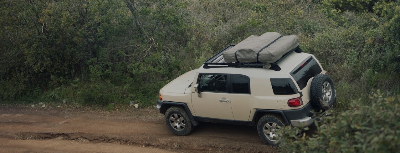 White SUV on mountain road | Breast Cancer Car Donations