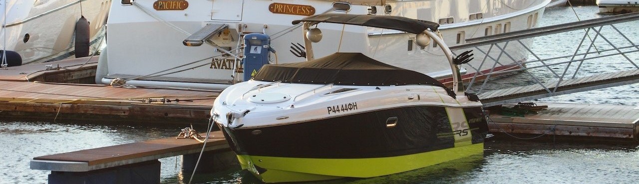 White Yacht Parked on Wooden Dock | Breast Cancer Car Donations