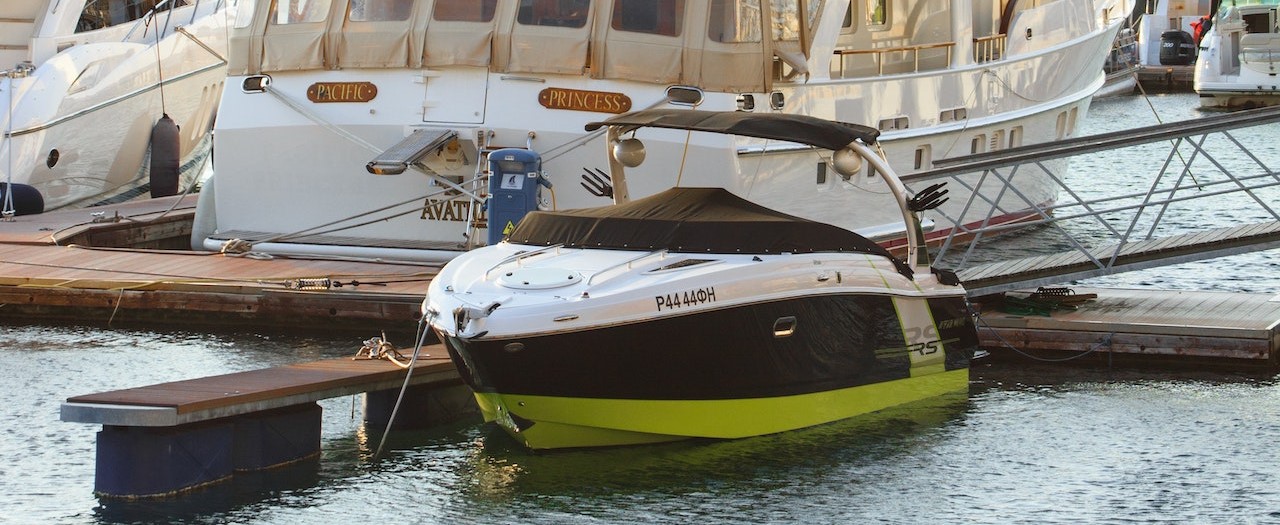 White Yacht Parked on Wooden Dock | Breast Cancer Car Donations