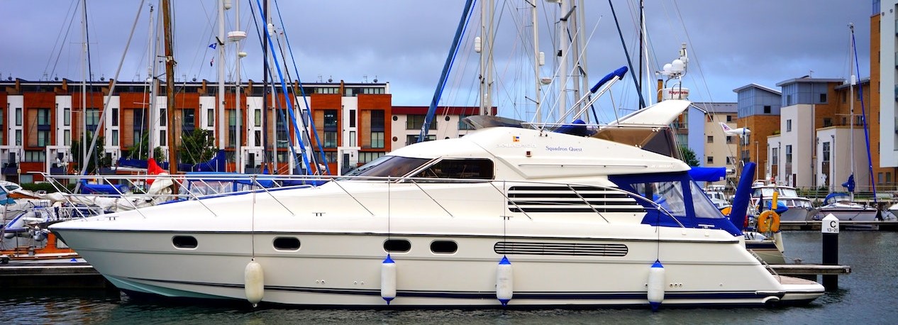 White yacht docked on the port | Breast Cancer Car Donations