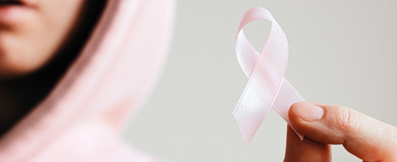 Woman Holding Pink Ribbon | Breast Cancer Car Donations