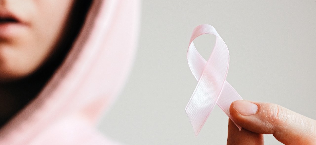 Woman Holding Pink Ribbon | Breast Cancer Car Donations