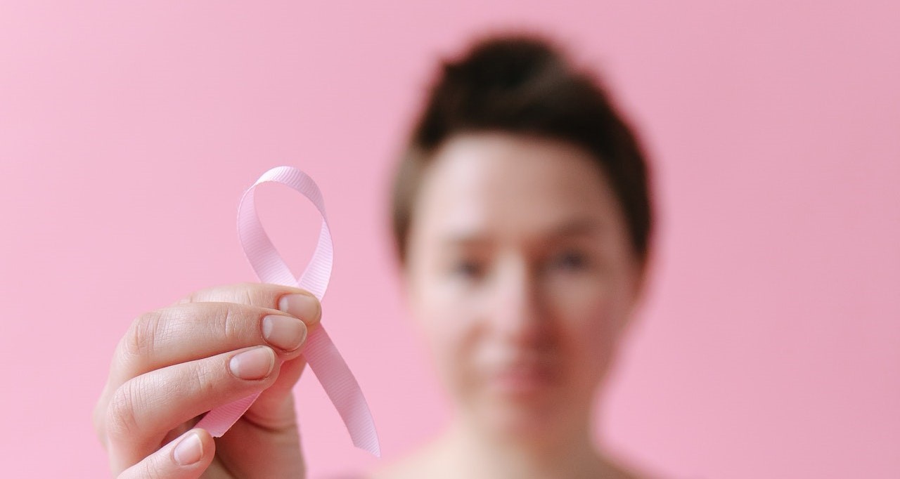 Woman Holding a Pink Ribbon | Breast Cancer Car Donations