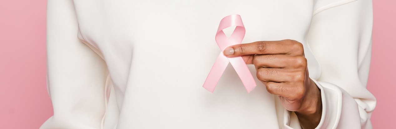 Woman In A White Hoodie Holding A Pink Ribbon | Breast Cancer Car Donations