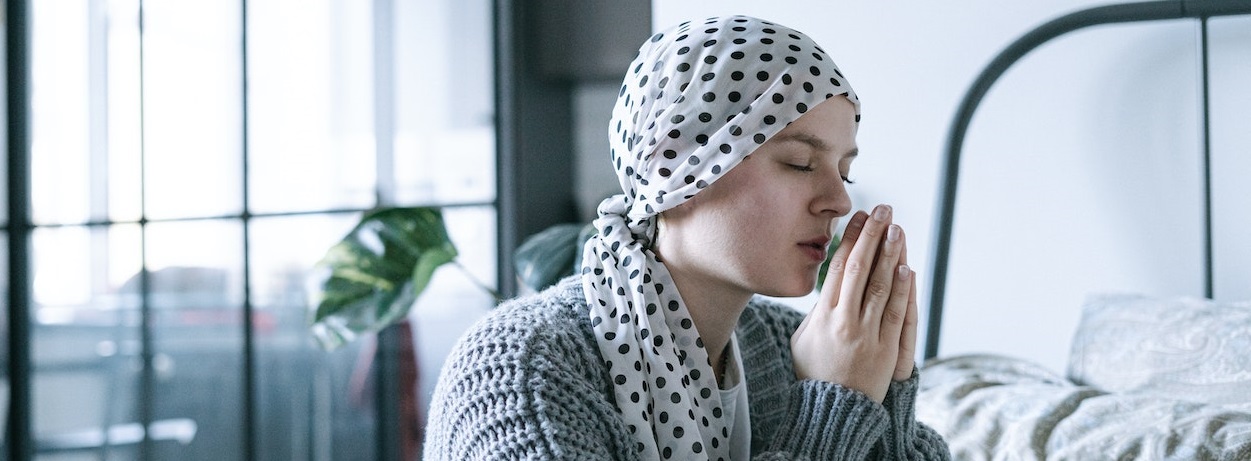 Woman with dotted headband praying | Breast Cancer Car Donations