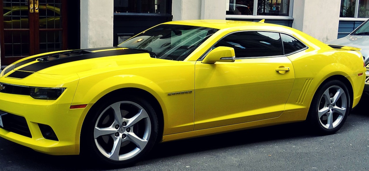 Yellow Chevroelt Camaro Parked Outside of Building | Breast Cancer Car Donations