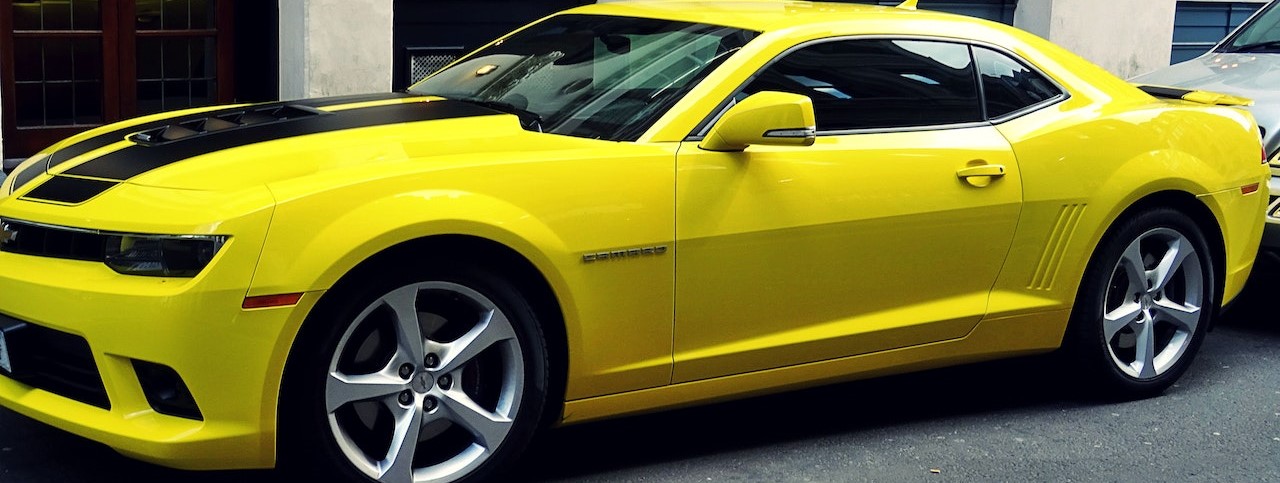 Yellow Chevroelt Camaro Parked Outside of Building | Breast Cancer Car Donations