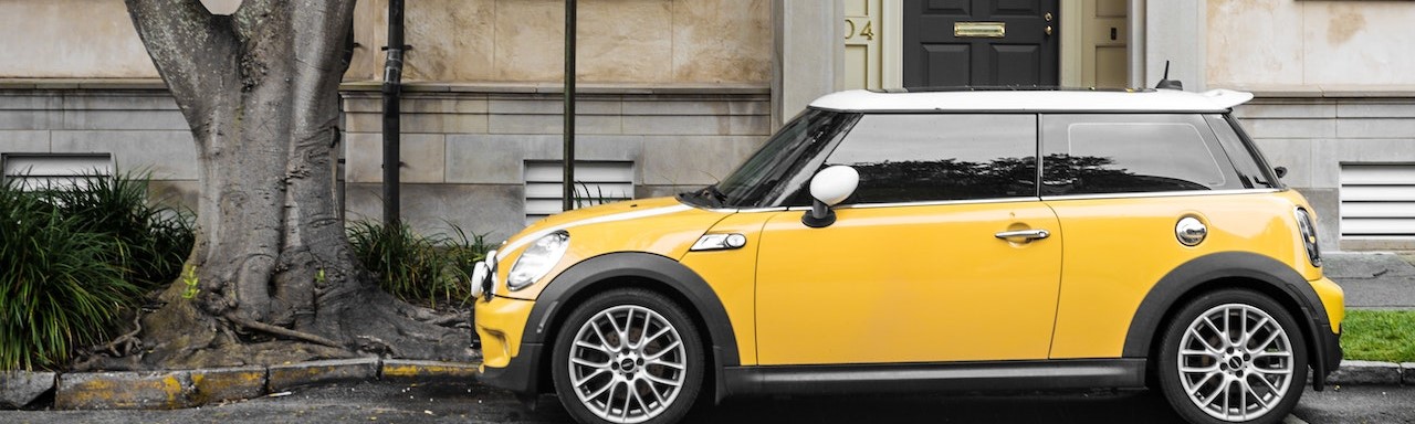 Yellow mini cooper parked on the side of the street | Breast Cancer Car Donations