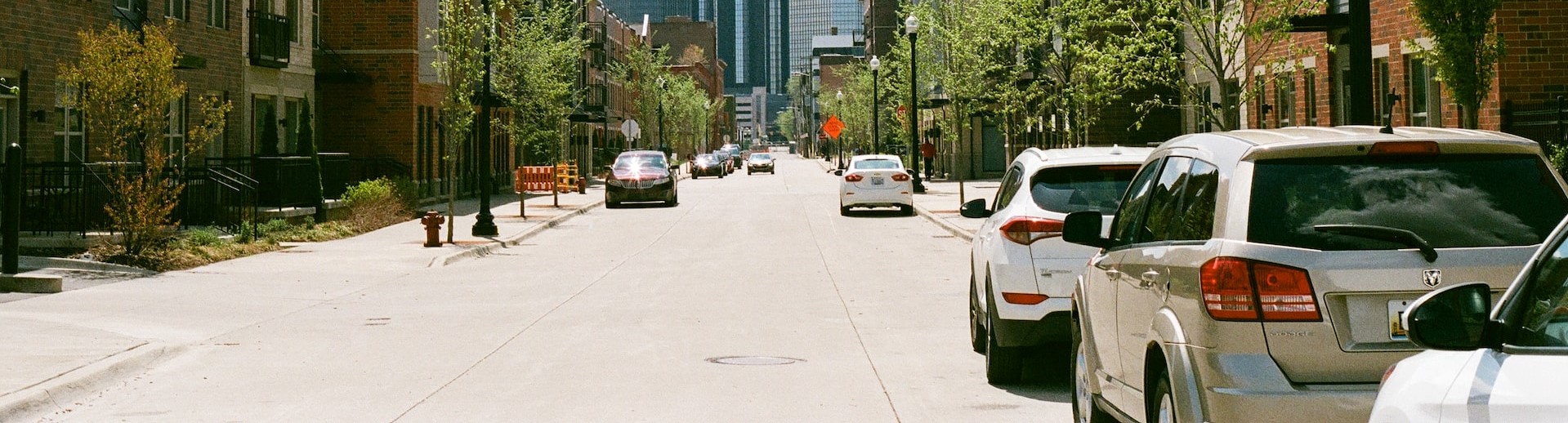 cars parked on side of the road near high rise buildings | Breast Cancer Car Donations