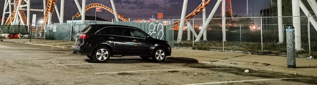 A Black Car Parked Near the Rollercoaster Railings | Breast Cancer Car Donations