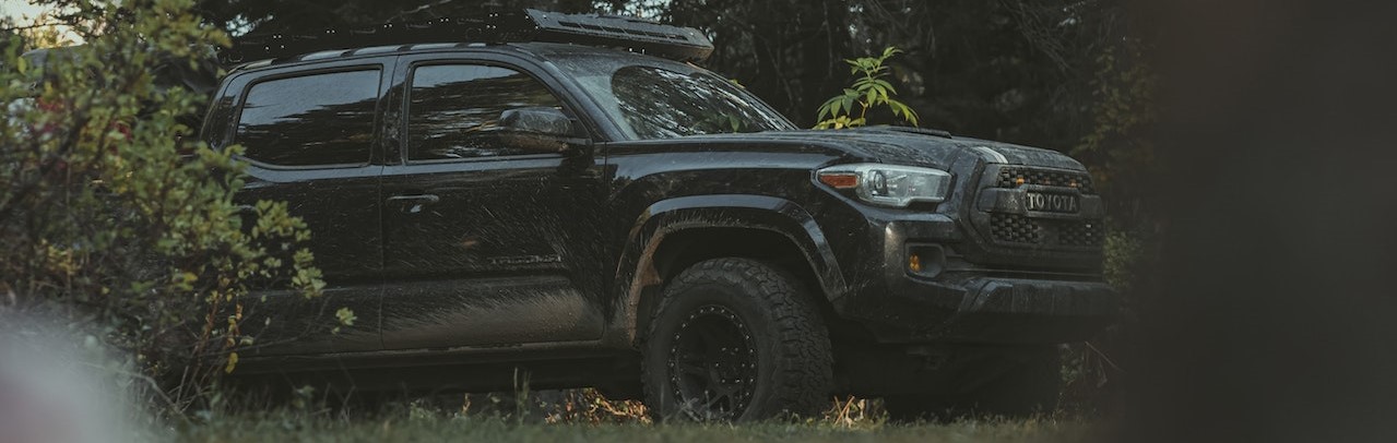 Black 4x4 Vehicle Parked in the Forest | Breast Cancer Car Donations