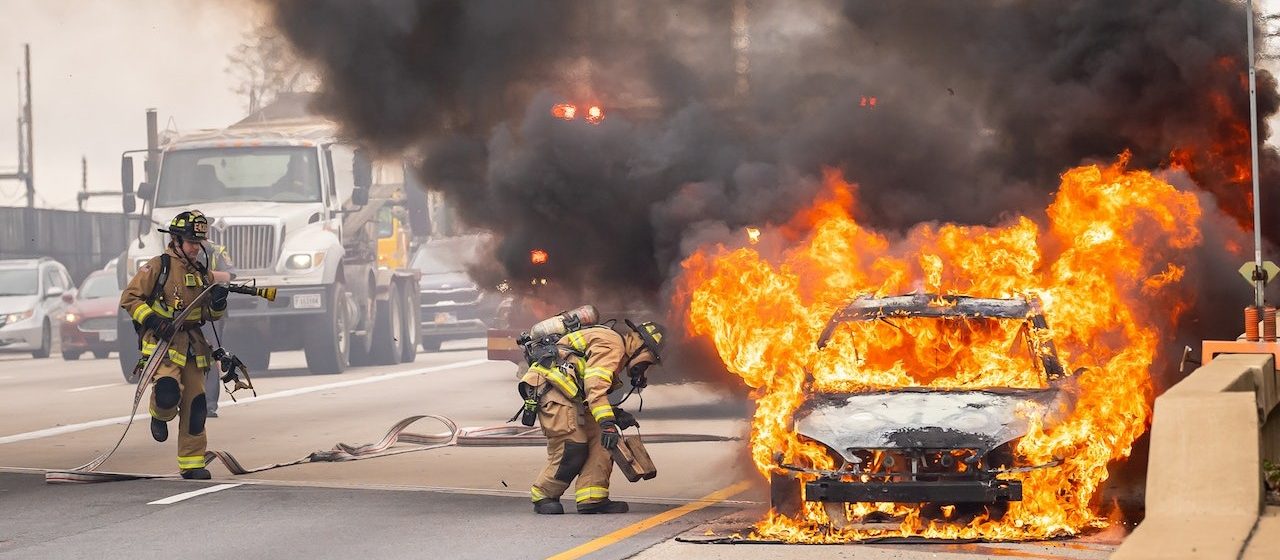 Firemen try to put out the fire on a car | Breast Cancer Car Donations