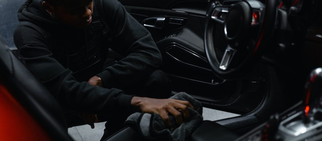 Man in Black Jacket Cleaning the Seat of a Car | Breast Cancer Car Donations