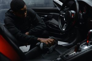 Man in Black Jacket Cleaning the Seat of a Car | Breast Cancer Car Donations