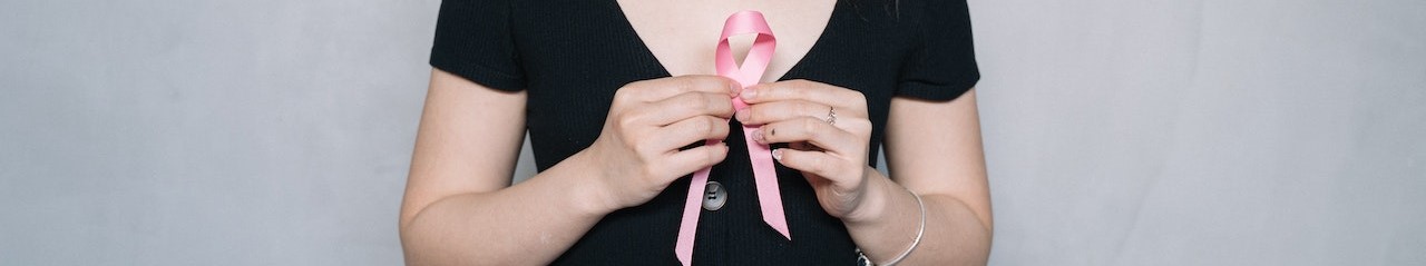 Woman Holding Pink Ribbon | Breast Cancer Car Donations