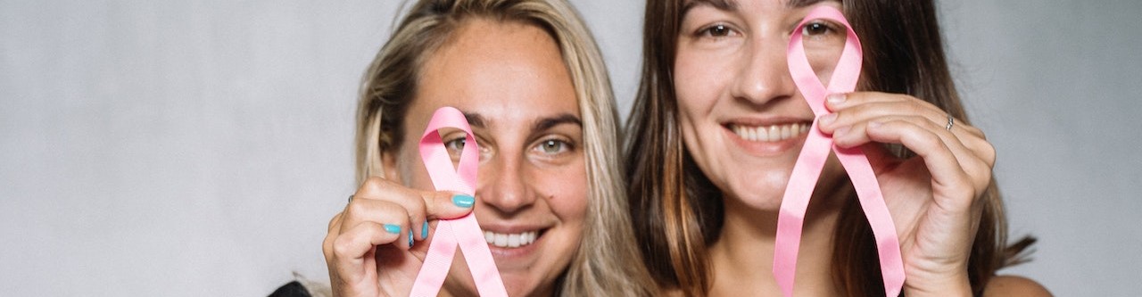 Women in Black Tank Top Holding Pink Ribbons | Breast Cancer Car Donations