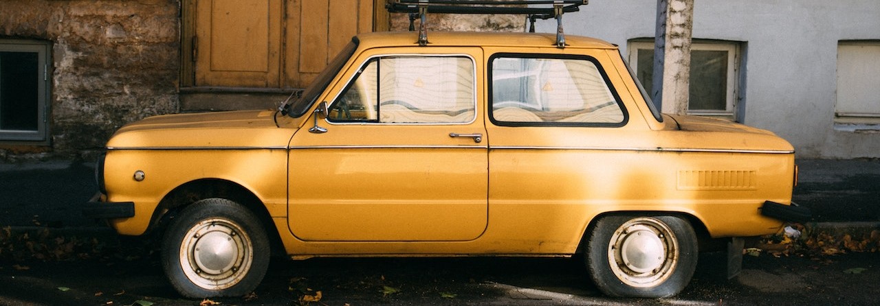 retro car parked outside old building | Breast Cancer Car Donations