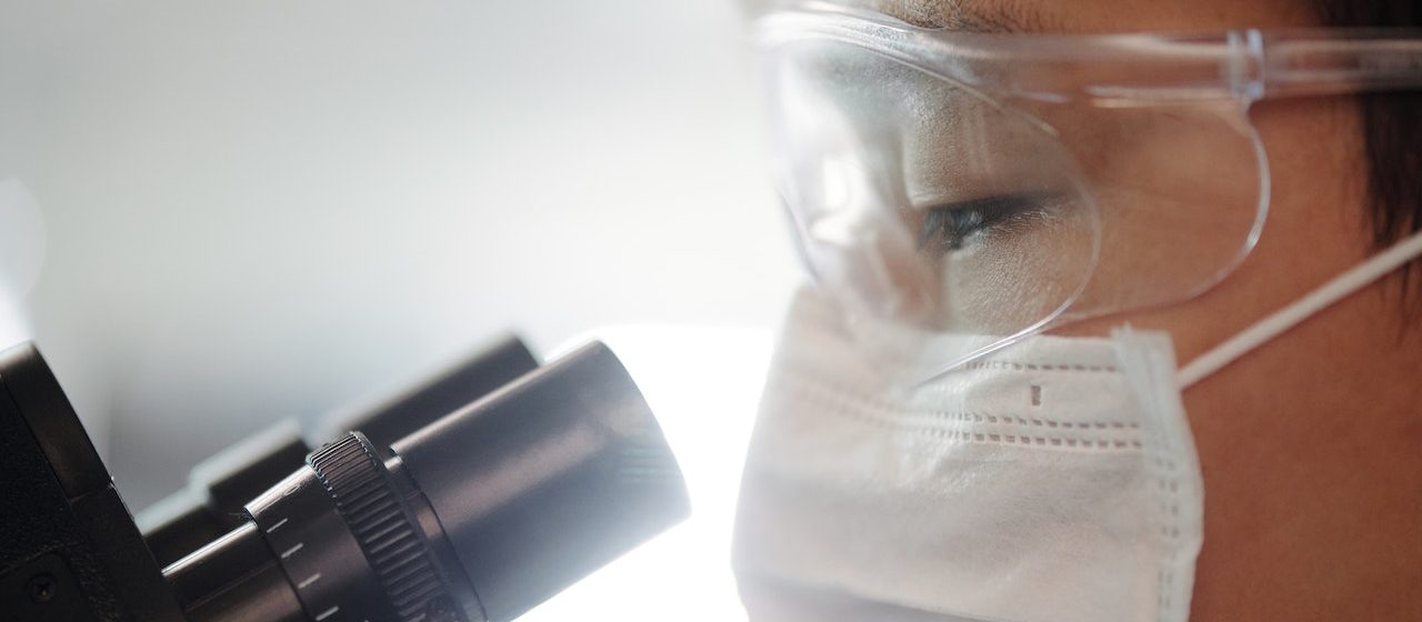 Man Looking Through A Microscope | Breast Cancer Car Donations