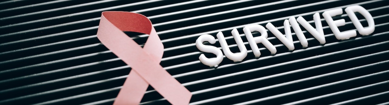 Pink Ribbon Beside a Note on a Letter Board | Breast Cancer Car Donations