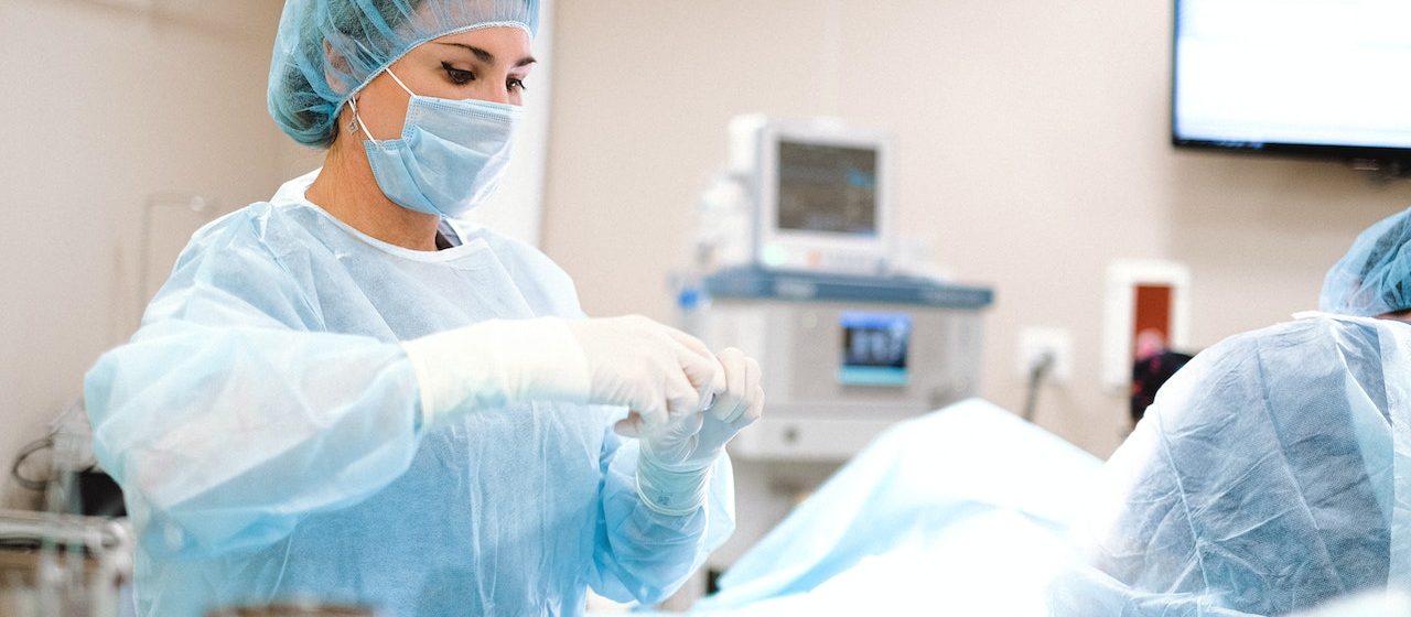 Woman in Blue Dress Shirt Wearing Blue Mask and White Latex Gloves | Breast Cancer Car Donations