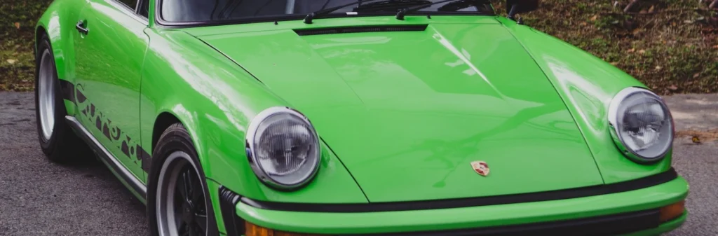 Green coupe parking near green field