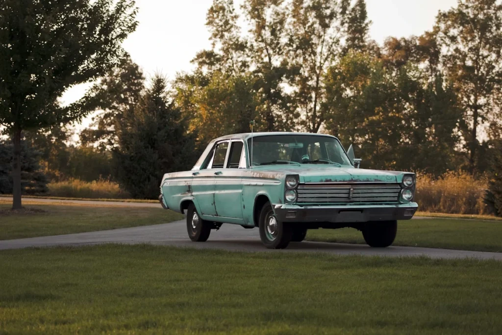 Photo of green sedan on gray concrete floor
