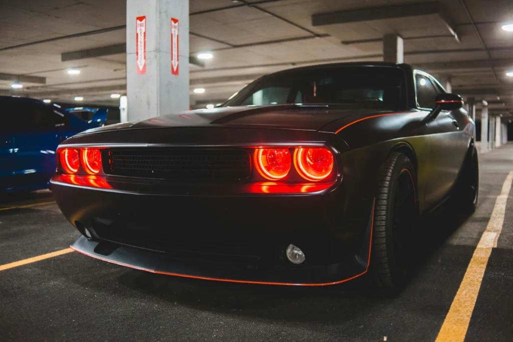 High-performance muscle car showcasing bold headlights in a modern parking garage setting