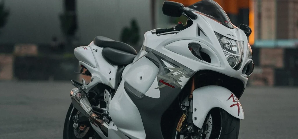 White motorcycle parked in urban area at sunset, capturing a modern and moody aesthetic