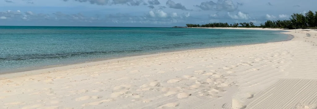 White sand beach under blue sky and white clouds during daytime