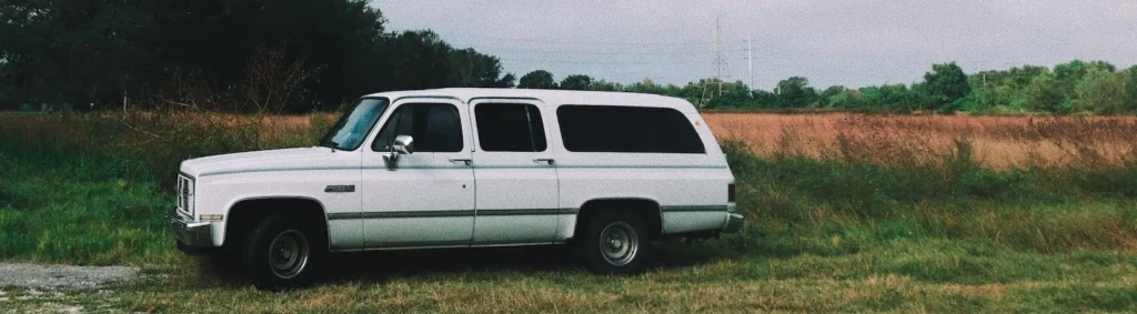White station wagon on grass field