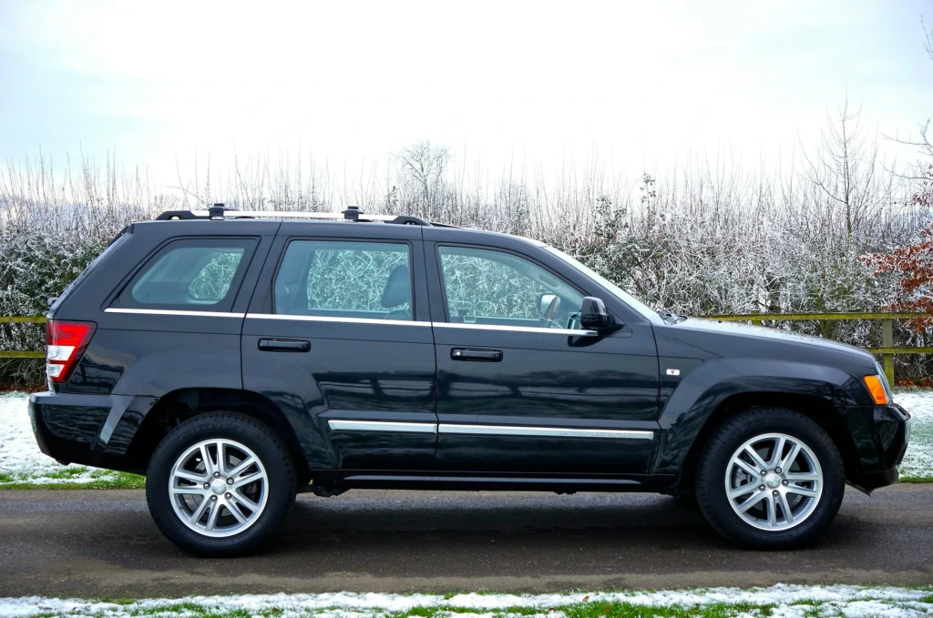 A black SUV parked outdoors on a snowy road surrounded by a winter landscape