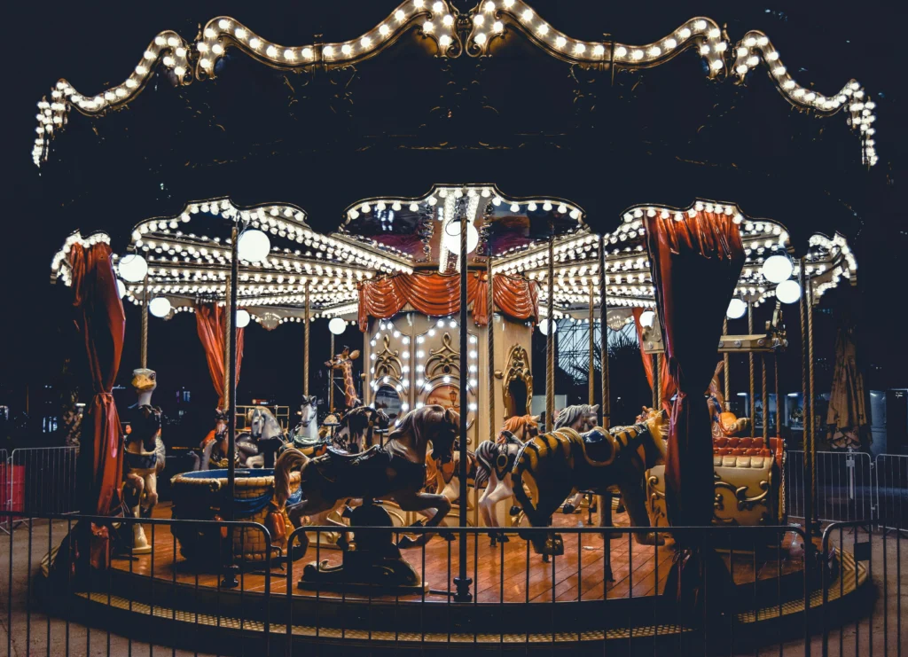 A beautifully illuminated carousel spins in night scene, capturing the whimsical charm of a classic fairground ride