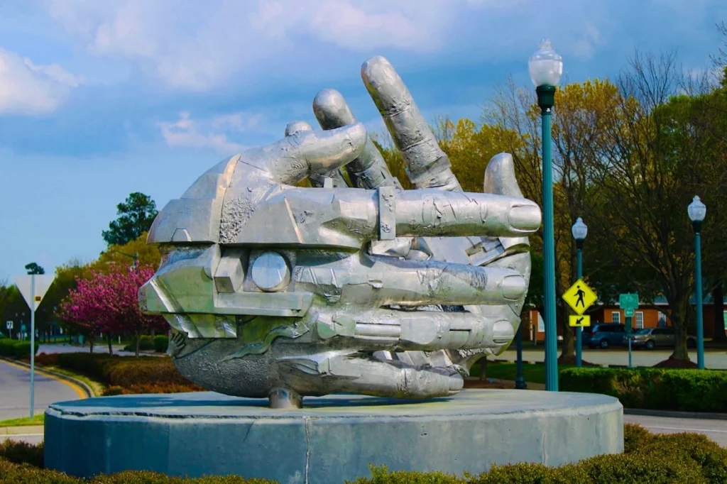 Gray concrete statue near blue metal fence during daytime, Newport News, Virginia