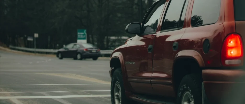 Red SUV waiting at a traffic light on a cloudy day in Reston, VA, USA