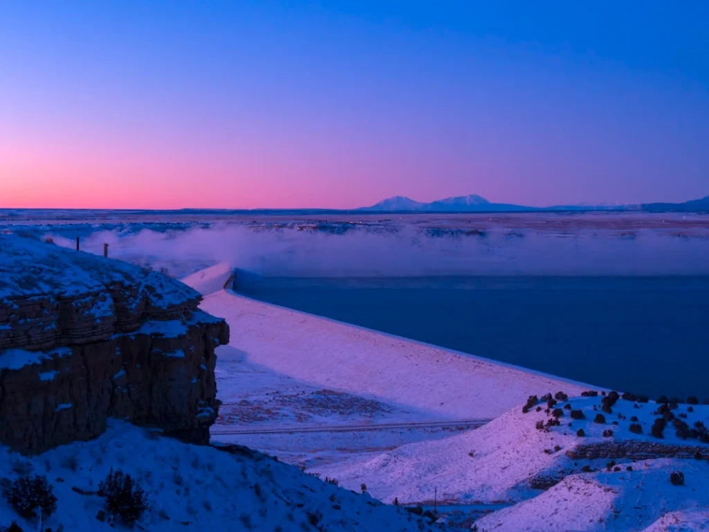 The sun is setting over a snowy landscape