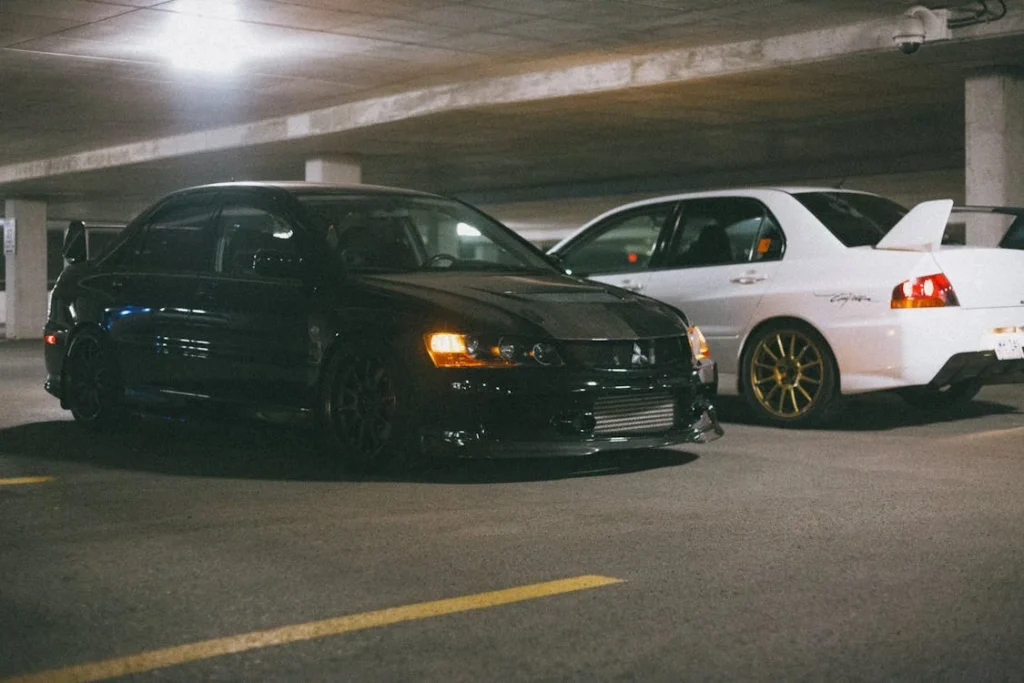 Mitsubishi Lancer Evolutions parked in an illuminated underground garage