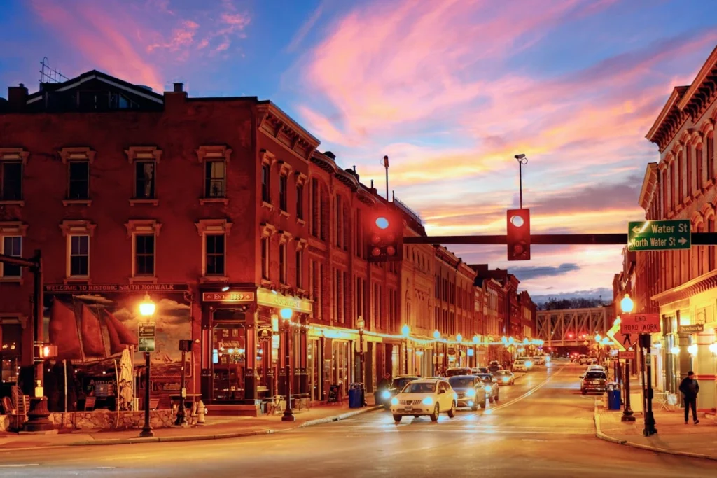 A street in Norwalk, CT, at dusk with a traffic light