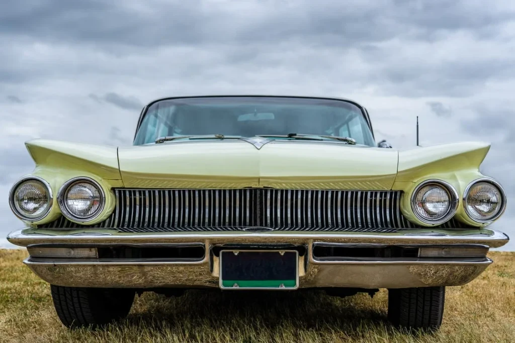 Front view of a vintage classic car with chrome detailing under a cloudy sky