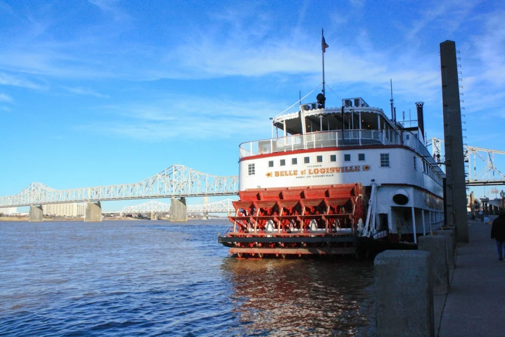 White and red river boat on sea under blue sky during daytime