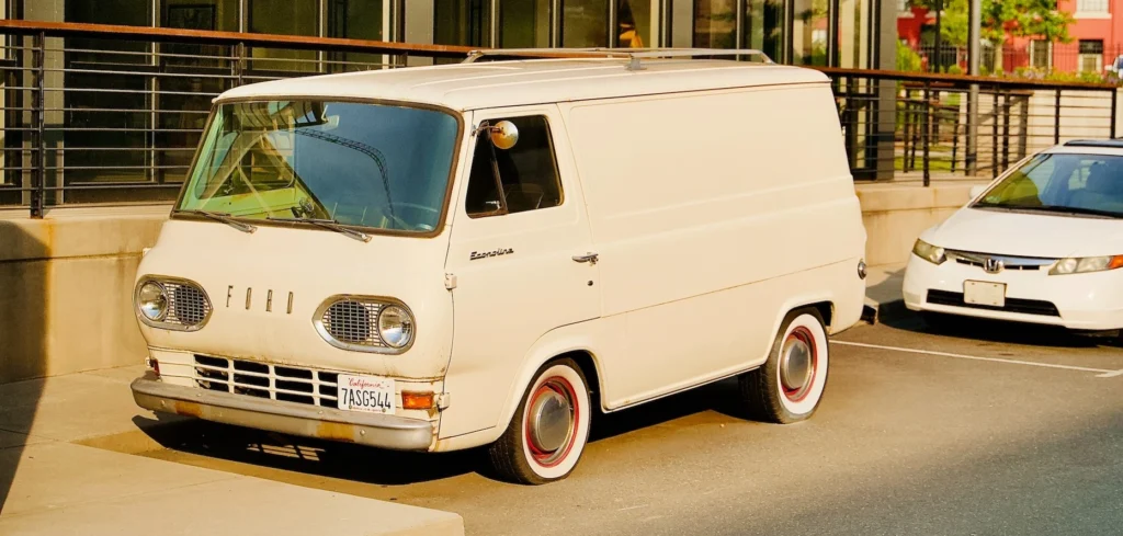 White van parked beside building during daytime